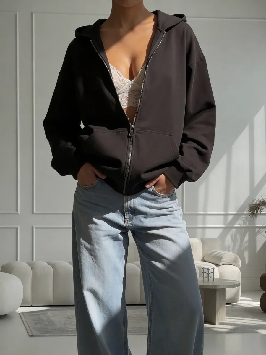 Model wearing a black NAZZANI oversize zip hoodie